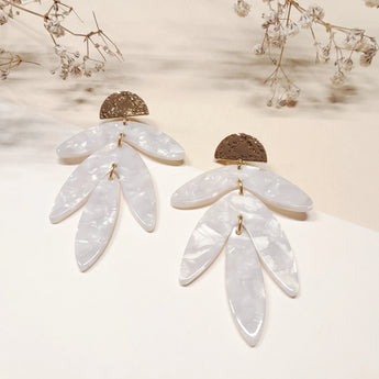 Boucles Martha de Fabien Ajzenberg en acétate blanc et plaqué or, au motif pendant inspiré des feuilles.